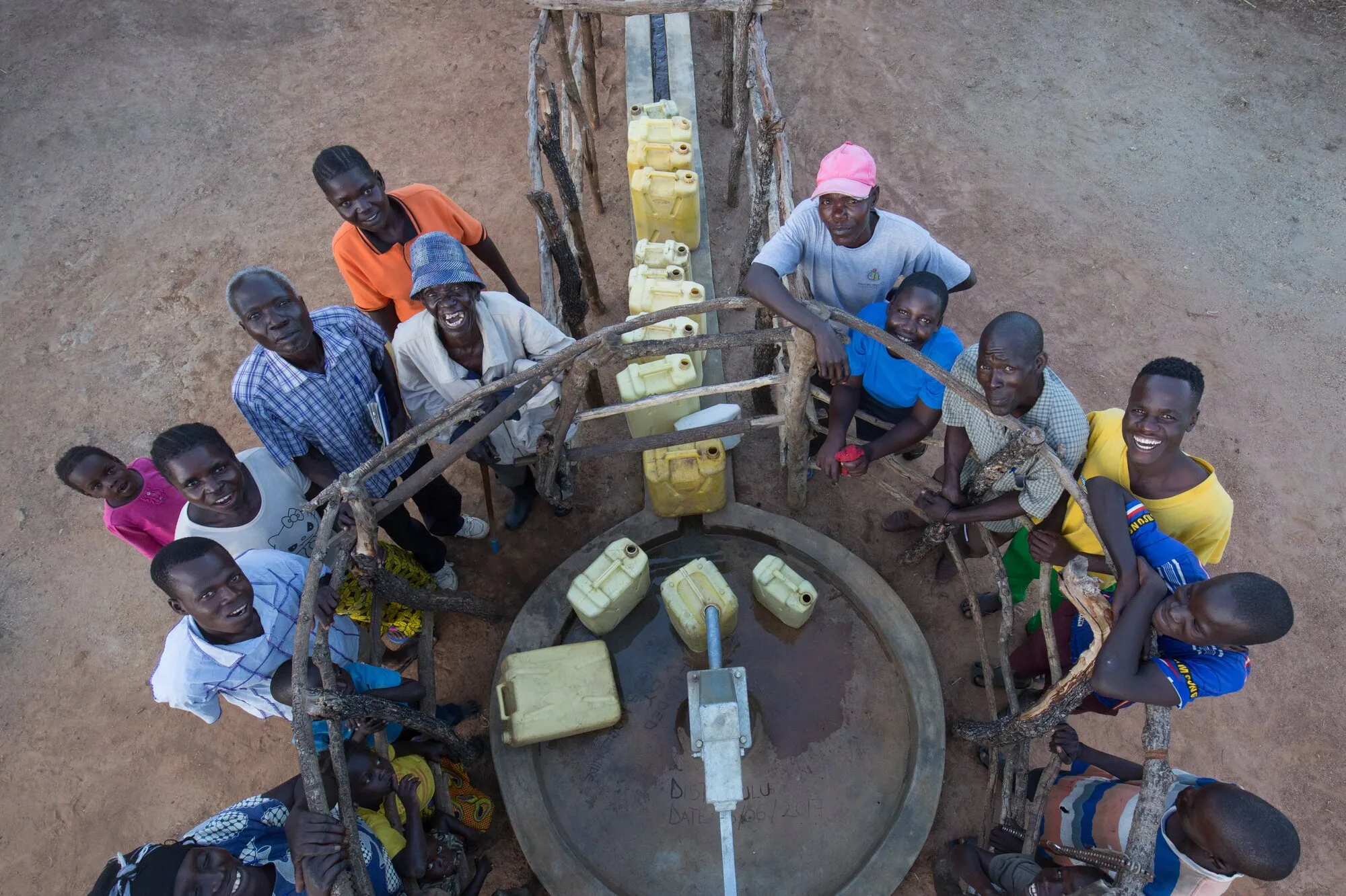 A borehole seen from above, with people round it looking up