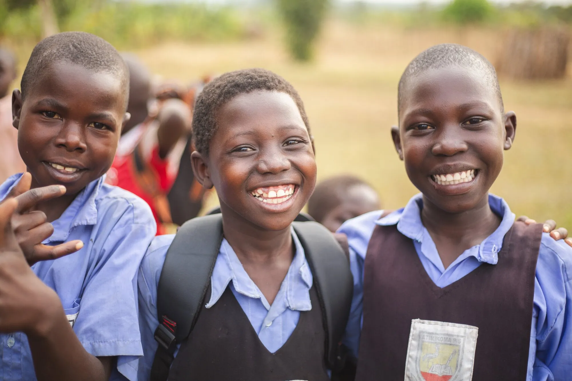 Three smiling schoolchildren in uniform