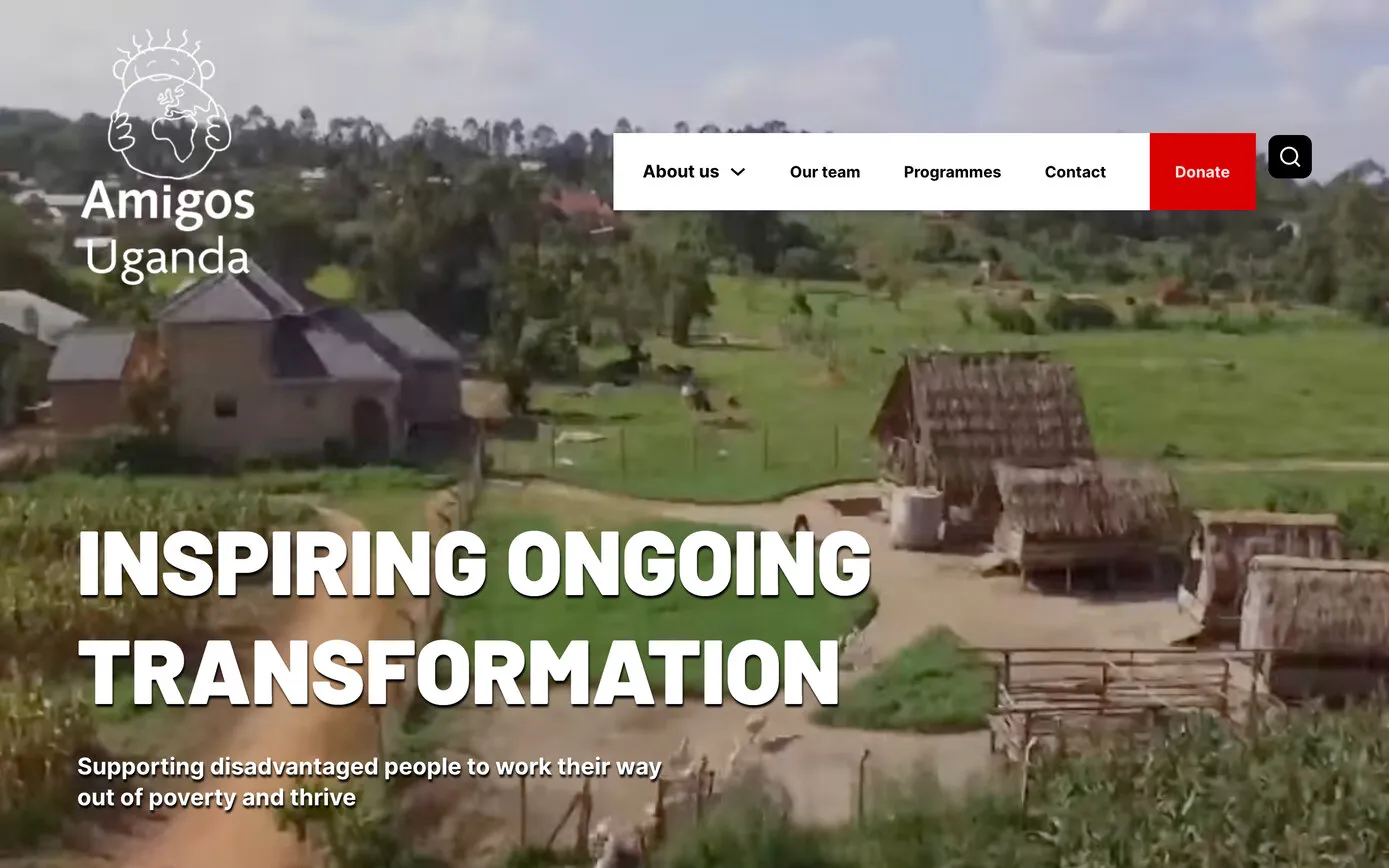 The Amigos Uganda homepage: the Amigos Uganda logo and a red Donate button over a view of a village with thatched huts and green fields
