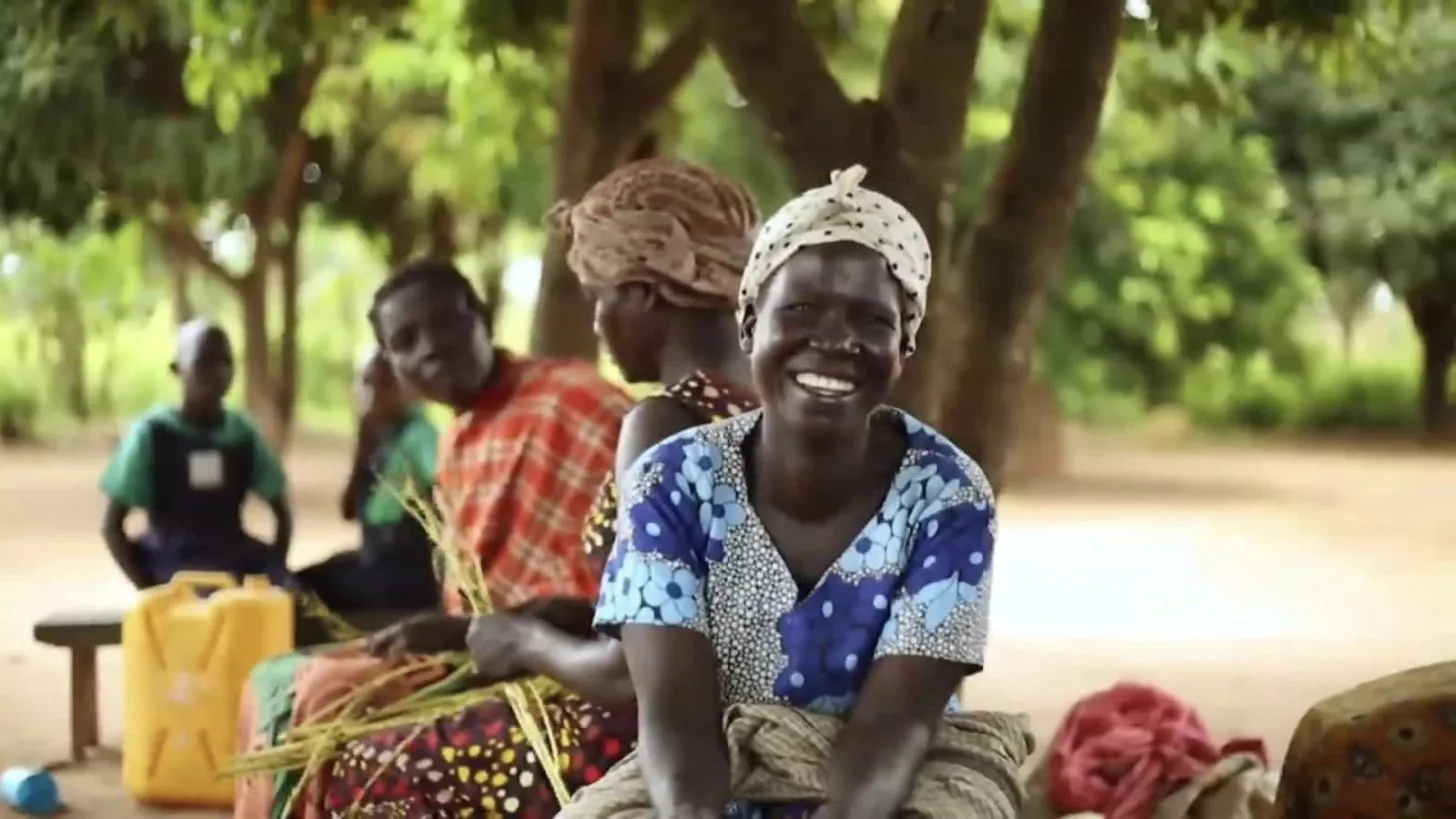 Women weaving baskets in rural Uganda, from the Amigos homepage film