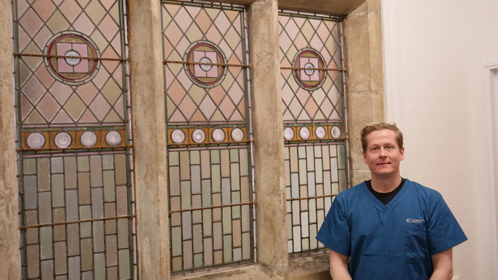 A location test: the practice manager standing in front of the stained-glass window