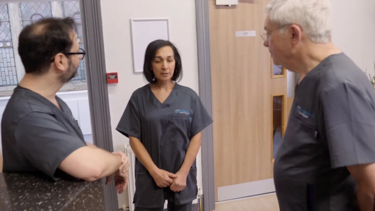 Leo, Dr Ahmad-Mear and a colleague walking the corridor towards the camera