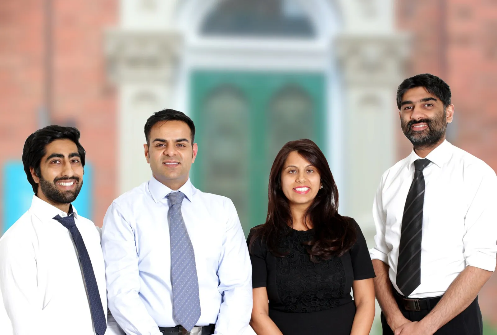 Four of K3 Dental’s specialists in front of the practice’s green front door