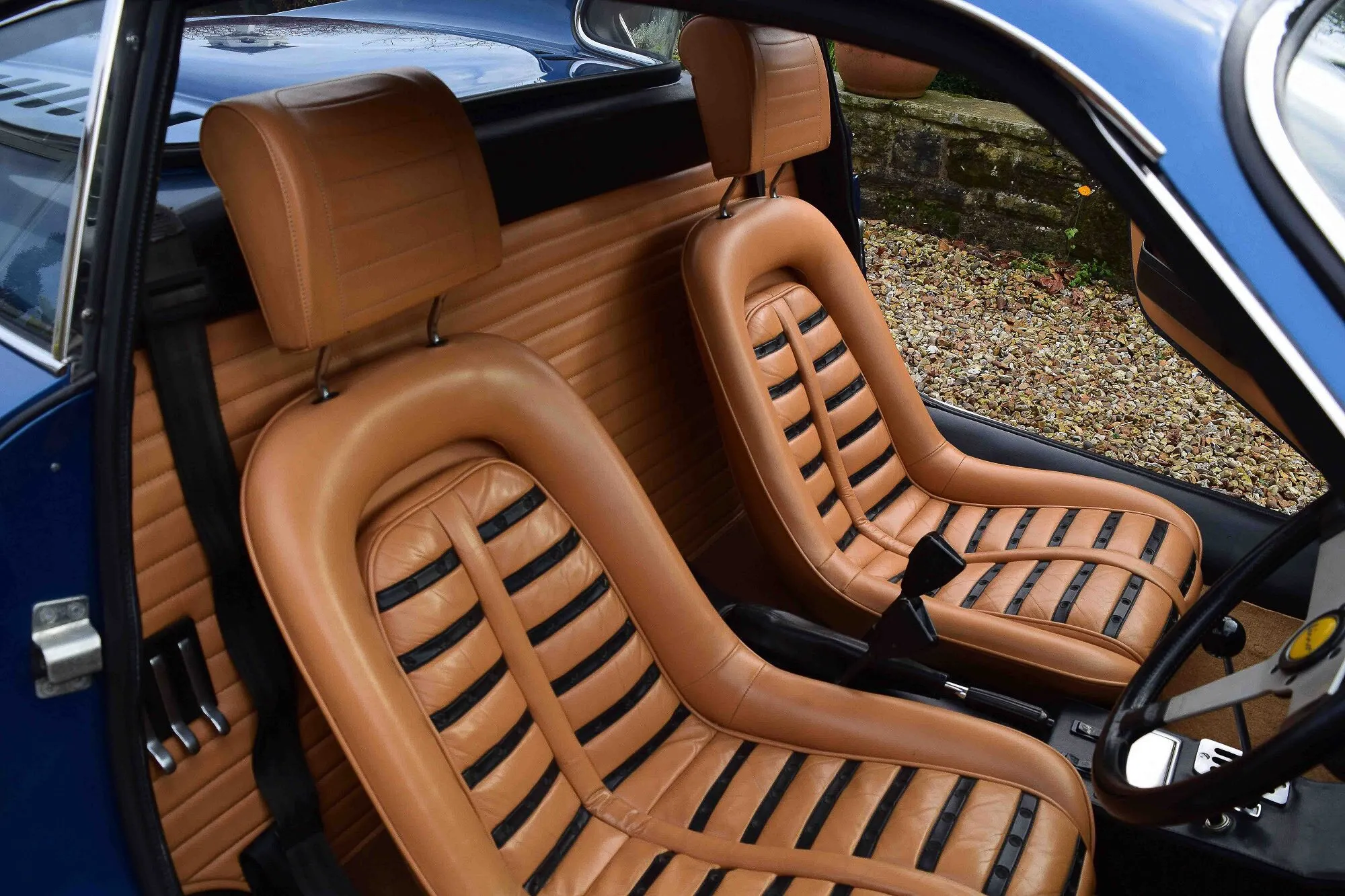Tan leather Daytona seats inside a blue Ferrari Dino