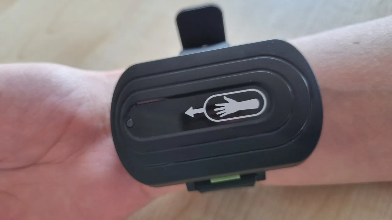 Close-up of the trial prototype on a wrist, with its hand-and-arrow symbol