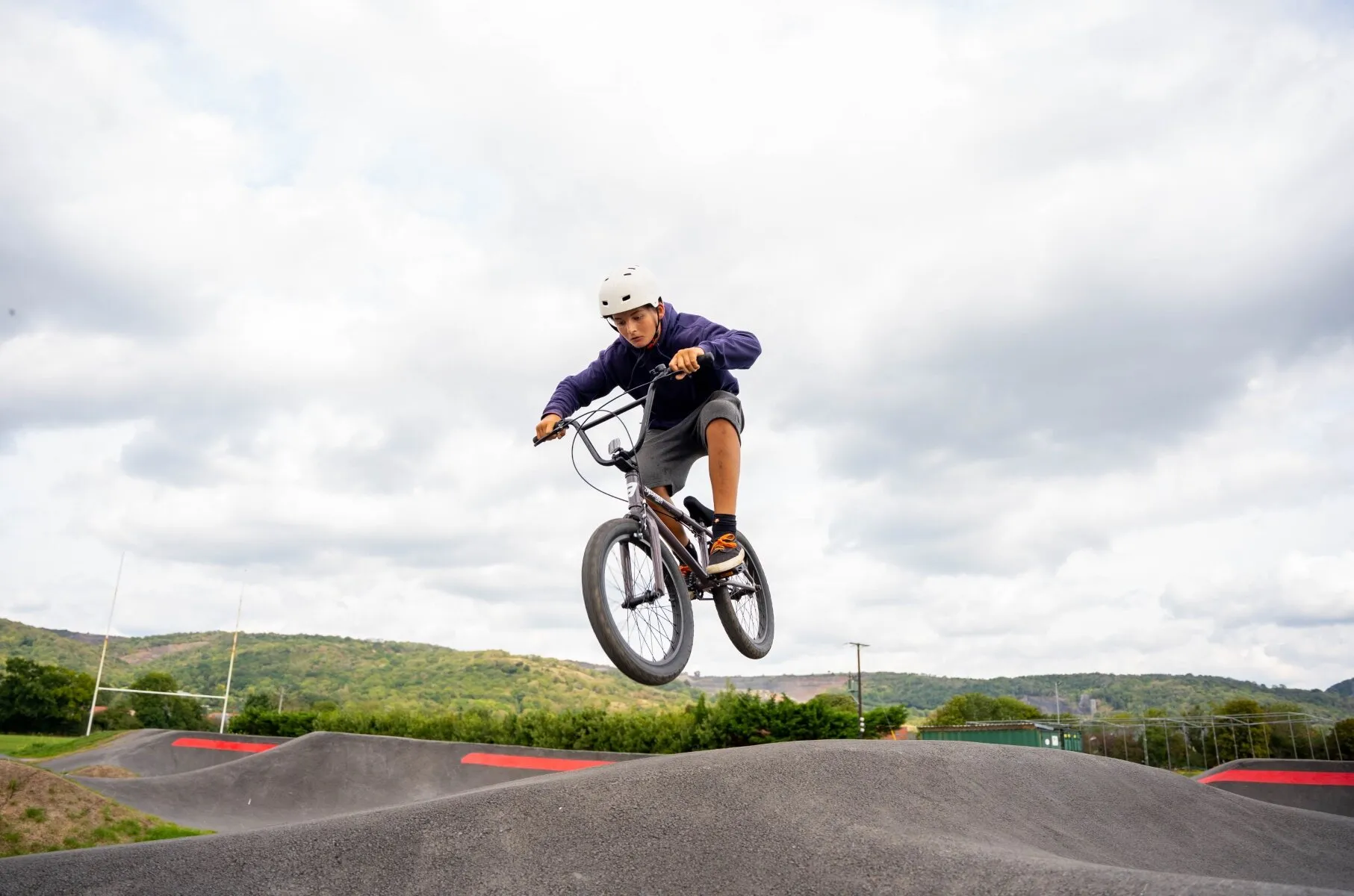 A rider in mid-air over a jump at a pump track