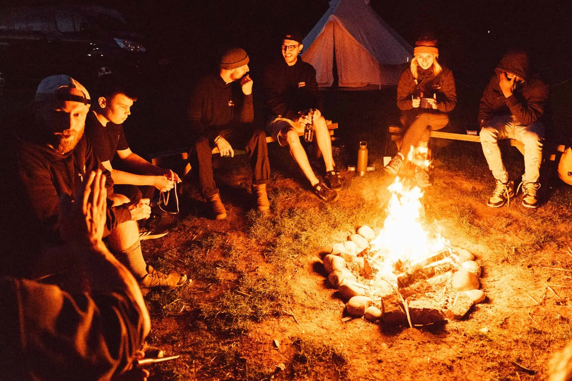 Young people and staff round a campfire at night