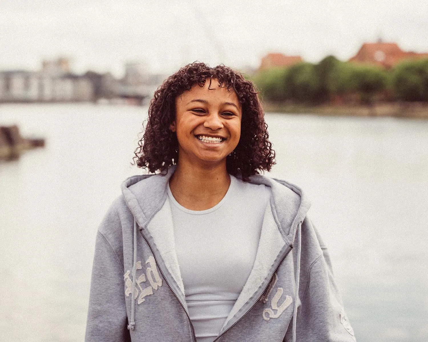 A young woman smiling by the river