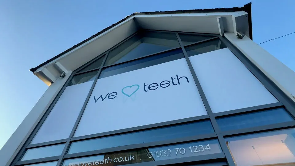 The practice building from below, “we love teeth” in the window and the phone number